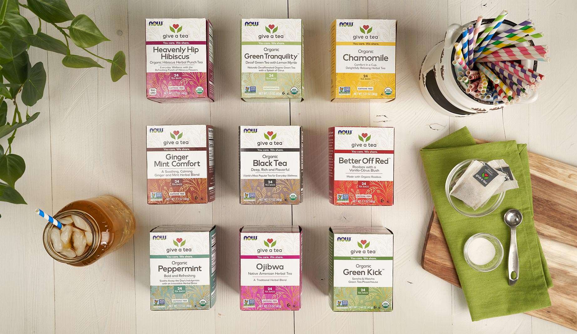 Give a Tea boxes on the counter including Heavenly Hip Hibiscus, Green Tranquility, Chamomile, Ginger Mint Comfort, Black Tea, Better Off Red, Peppermint, Ojibwa and Green Kick