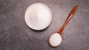 white bowl and wooden spoon full of Erythritol