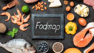 small chalkboard sign with "Fodmap" surrounded by fresh foods, fish, veggies, cheeses etc