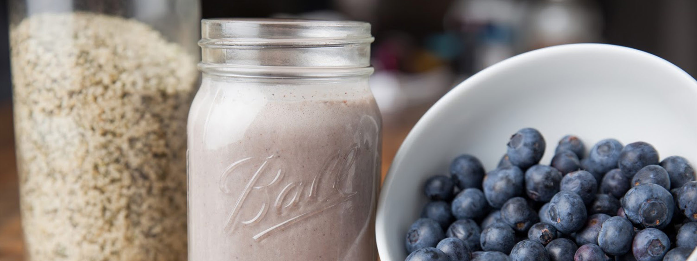 fruit smoothy next to oats and a bowl of blueberries