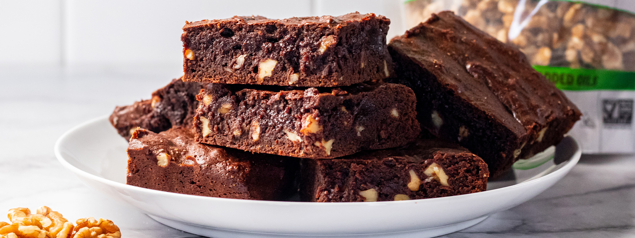 white plate with fudgy walnut brownies on them