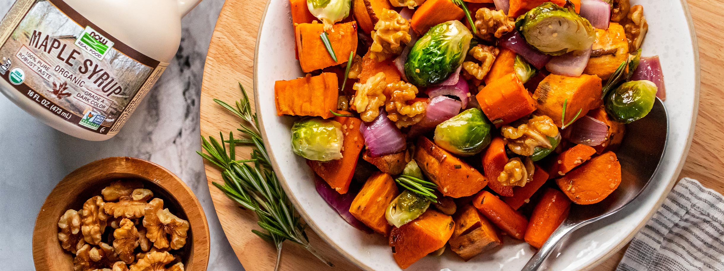 white bowl filled with Maple Butter roasted vegetables bottle maple syrup