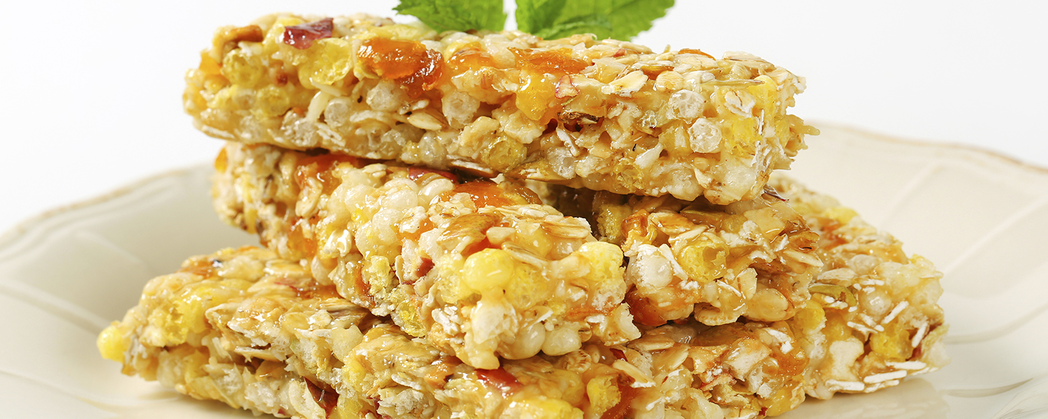 A clear decorative plate is topped with several Chewy Coconut Granola Bars