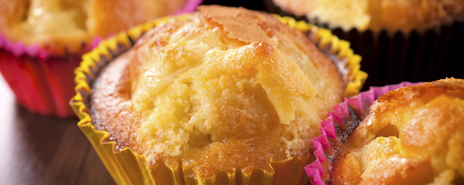 A closeup of several Gluten Free Plain Muffins decorated in yellow and pink wrapping.