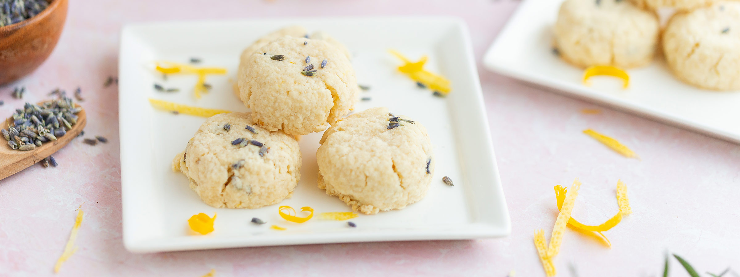Lemon Lavender Shortbread Cookies on a white plate sprinkled with lavender flowers and Lemon peels