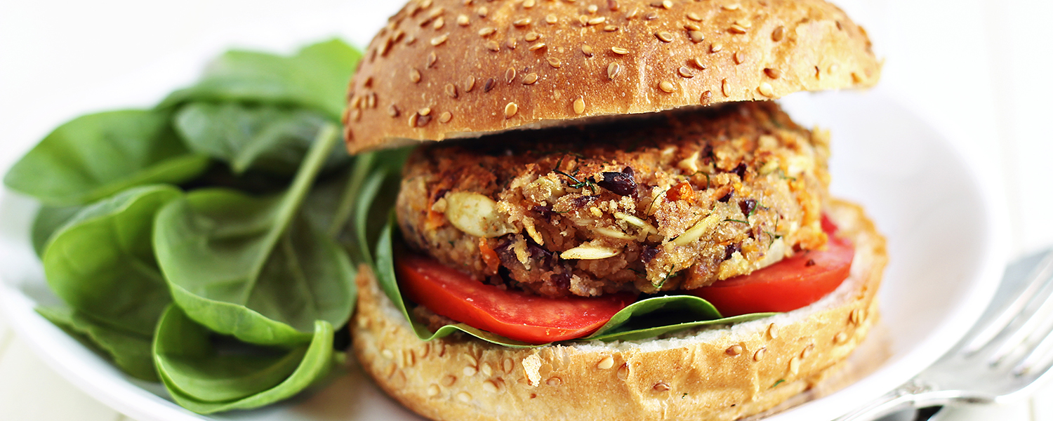 A white ceramic plate holding a Mediterranean Black Bean Veggie Burger