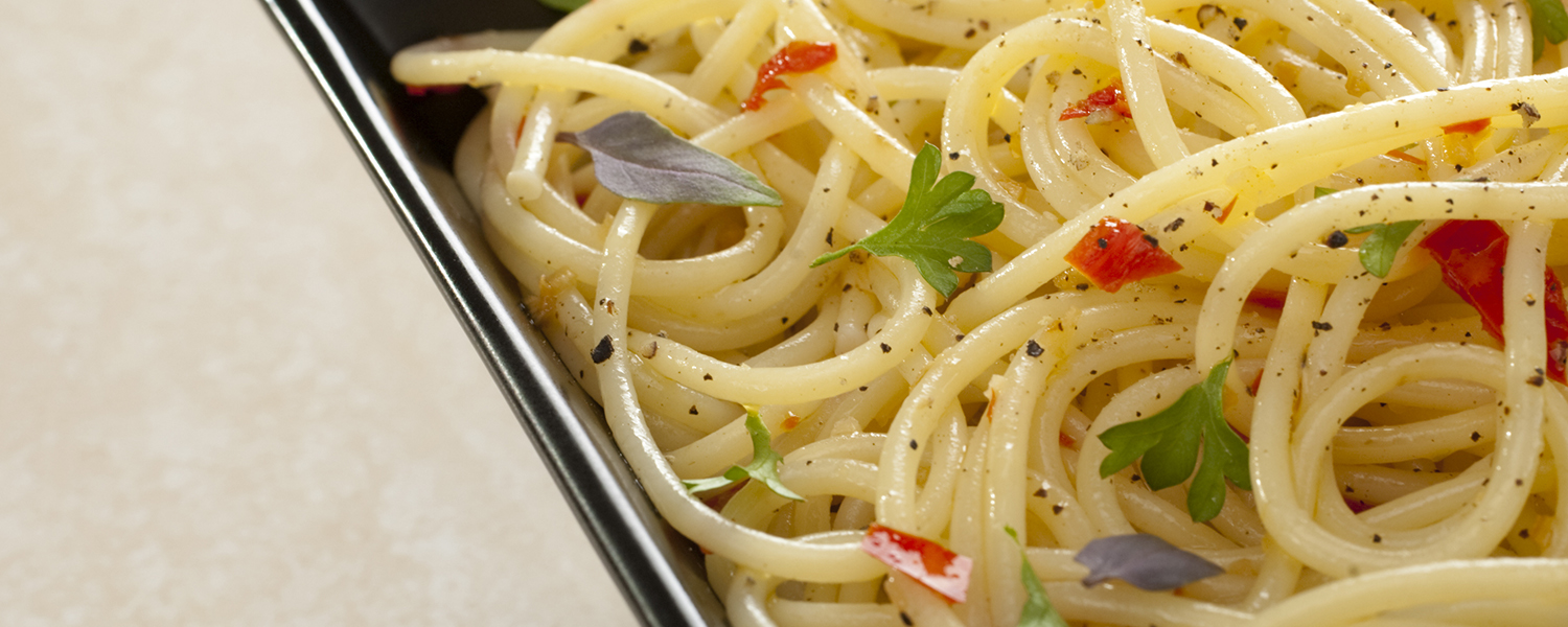 A black plate holds a serving of Sundried Tomato Sage Pasta.