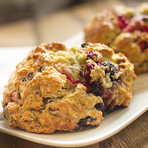 A closeup of a Triple Berry Scone on a white ceramic platter