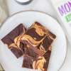 overhead view of white plate with several peanut butter swirl brownies and a  partial view of a bag of NOW Monk Fruit Sweetener laying next to the plate on the right