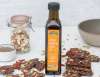 Chocolate Pumpkin Seed Superfood Bark stacked next to a bottle of pumpkin seed oil