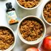 top view of Apple Walnut Toffe Crisp in 4 ramekins next to bottle of better stevia toffee flavor