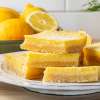 white plate containing No Sugar Added Lemon Bars next to jar of NOW BetterStevia powder