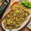 top view of quinoa spahetti with walnut pest between a bottle of olive oil and NOW pasta