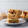 3 steel cut oat golden and coconut bar square stacked on white plate