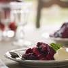 A white dinner plate is filled with Berry Compote, a dessert