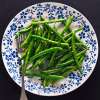 A white and blue plate is covered with Cashew Green Bean Stir Fry