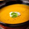 A closeup of Curried Cauliflower Soup in a black soup bowl