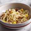 A white ceramic bowl on a white marble counter holds a serving of Gluten Free Pasta