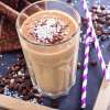 A drinking glass filled with a Mocha Espresso Smoothie on a wooden table