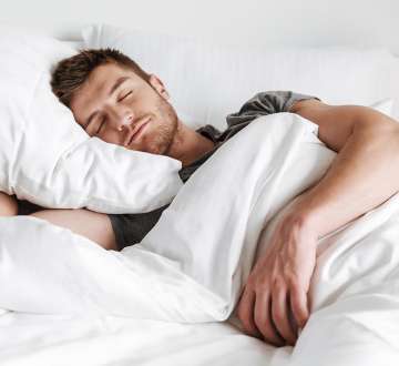 light skinned, male presenting person sleeping 