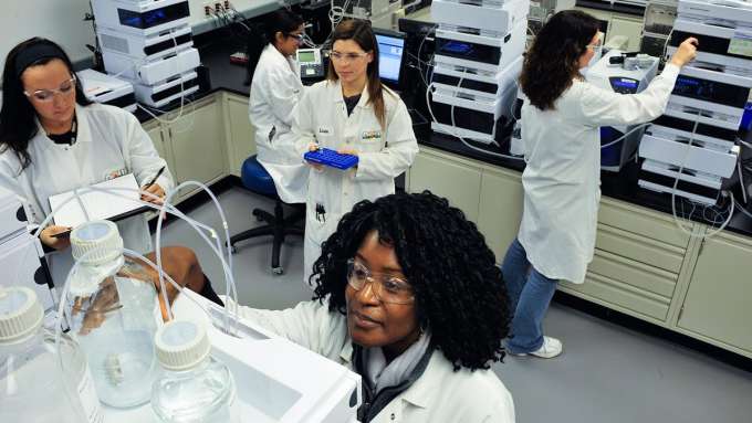 five females of mix races working in a lab to test various things