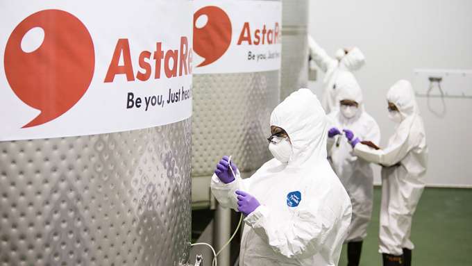 four people in white hazard suits working around Asta astaxanthin containers