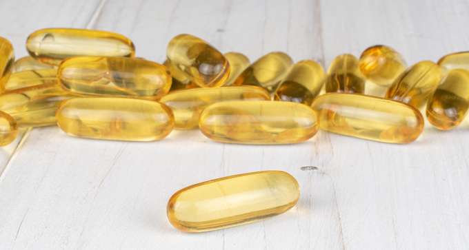 fish oil capsules on white wood