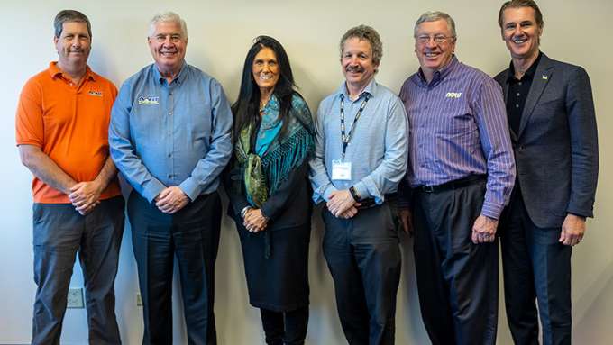 NOW board of directors - six people standing against a white wall - five presenting as men and one presenting as a woman