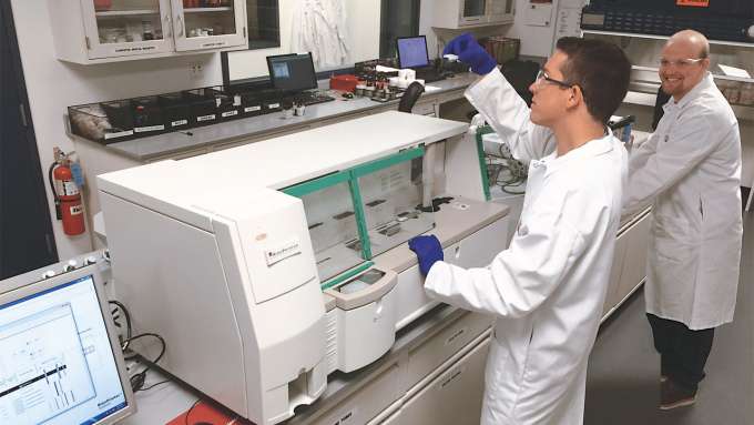 male presenting person checking test results next to riboprinter