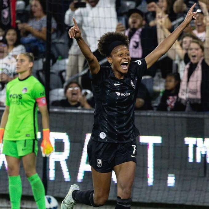 Simone Charley running with her arms in the air celebrating