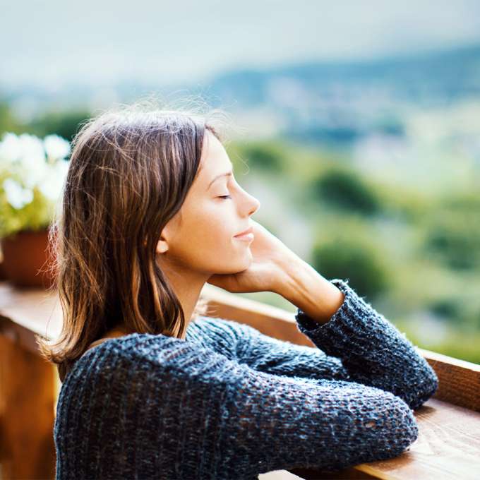 light-skinned, female presenting person taking deep breath of fresh air. 