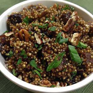 A white ceramic bowl is filled with Cumin-Infused Acai Quinoa