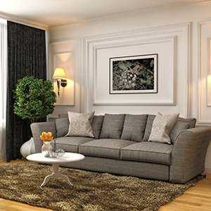 A modern living room with a grey accented couch and a brown rug on wooden floor