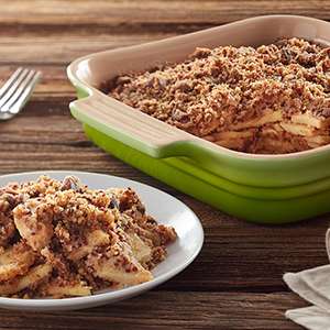 A green pan on a table holds Gluten Free White Quinoa Streusel. A fork also sits on the table.