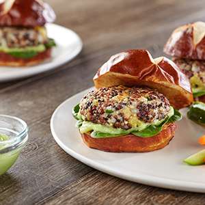 A white ceramic platter on a wooden table holds several Quinoa and Chia Sliders