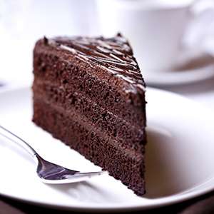 A closeup of a piece of Gluten Free Vegan Chocolate Cake on a white ceramic plate