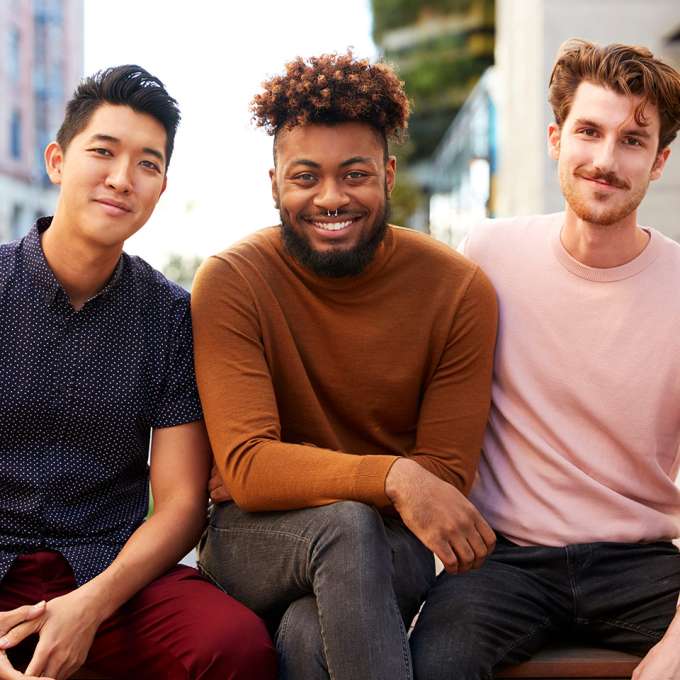 Three diverse Male Presenting Individuals sitting together