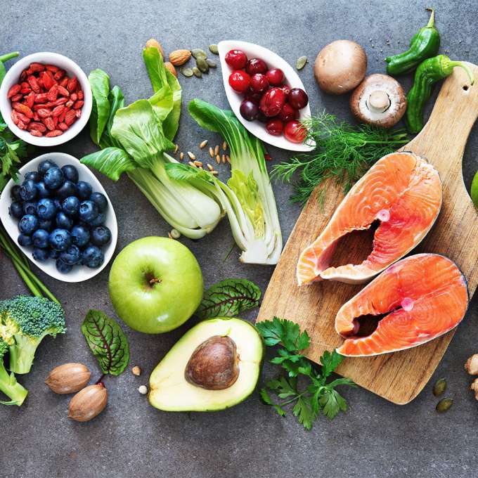 several groups of vegetables, fruits and two large salmon steaks