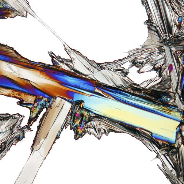 A closeup of a crystalized mineral. The light refracting through it makes certain parts appear multi