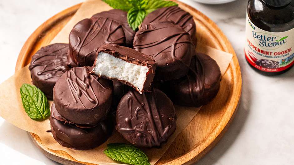 wood plate containing coconut peppermint patties next to bottle of NOW peppermint BetterStevia liquid