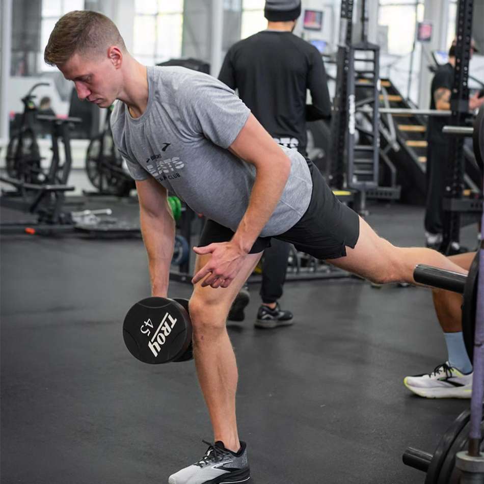 light skinned male presenting person working out in gym 