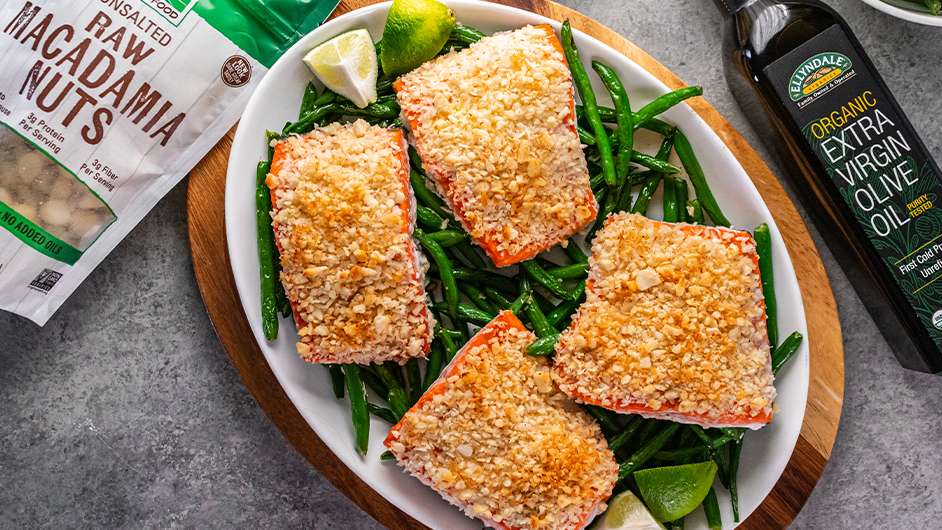 top view of Macadamia-Nut-and-Coconut-Crusted-Salmon next to bottle of Ellyndale Olive Oil and NOW Raw Macadamia Nuts