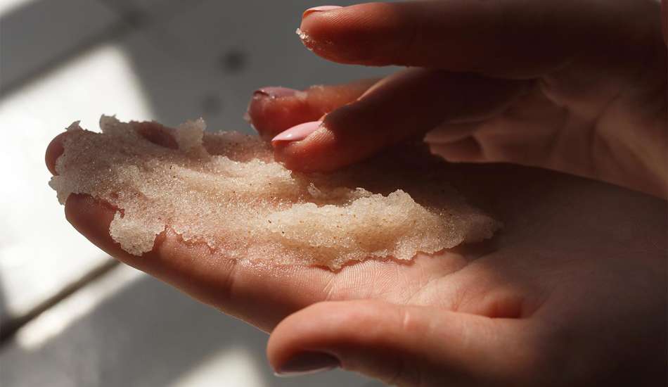 female presenting light skinned hands with sugar scrub 