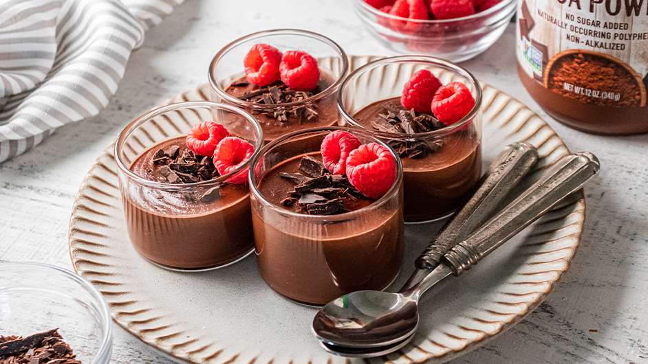 clear glass cups of vegan double chocolate Panna cotta with rasberries on top 